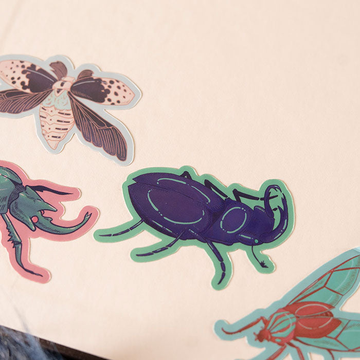 Amethyst Stag Beetle Holographic sticker on a sketchbook